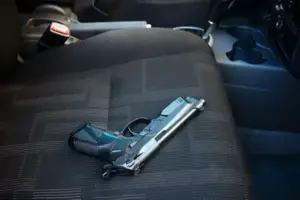 An unprotected pistol on a car seat 