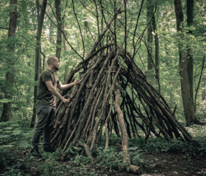 Man creating shelter out of branches